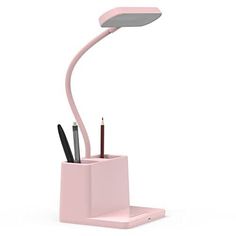 a pink desk lamp with two pens and pencils in the holder, on a white background