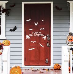 a front door decorated for halloween with bats and pumpkins