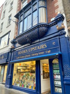 a blue storefront with books up stairs on the front and side of it's building