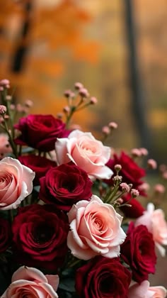 a bouquet of red and pink roses sitting on top of a table