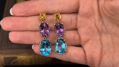 These striking dangle earrings are each accented with one (1) natural citrine, one (1) natural amethyst and one (1) natural topaz set into four- prong heads. The earrings measures 43.0mm in length and 12.2mm in width. The earrings are finished with friction style backs. The gems show light abrasion but nothing distracting. Elegant Multi-stone Topaz Gemstones, Gem Show, Greenish Blue, Show Lights, Ruby Jewelry, Natural Citrine, July Birthstone, One 1, High Quality Jewelry