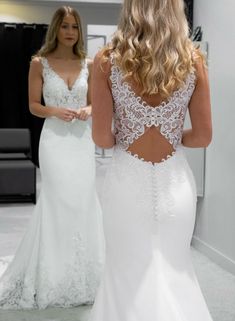 two women in wedding dresses looking at each other's back, one wearing a white dress