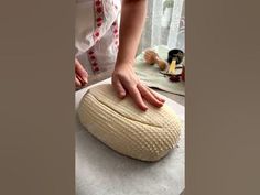 a woman is kneading an uncooked bread on top of a table