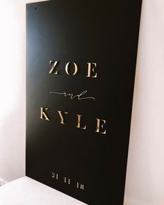 a black and gold wedding sign with the words zoe and kyle on it