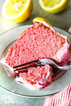 a slice of red velvet cake on a plate with a fork and two lemons in the background