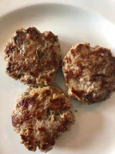 three hamburger patties sitting on top of a white plate