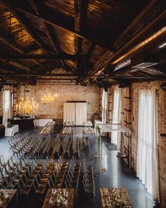 an empty room with tables and chairs set up for a wedding reception in the center