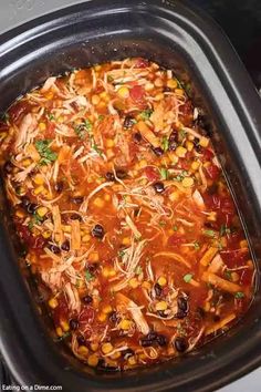 a crock pot filled with chicken, beans and tortilla soup is ready to be cooked