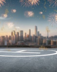 an empty parking lot in front of a city skyline with lots of fireworks on it