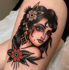 a woman's tattoo with flowers on her thigh