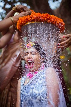 a woman is sprinkled with water from her head