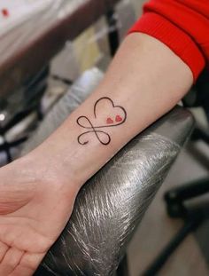 a person with a heart tattoo on their wrist