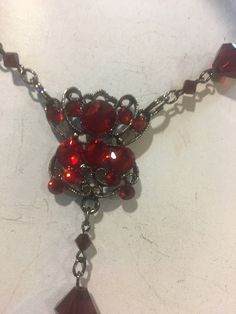 This is a beautiful red long necklace that can be adjusted and used multi ways. Wrap it around your neck for a choker look or adjust it to fit however you wish. Ruby red crystal beads plated in black . Cross has crystals on both sides. Red Metal Choker For Party, Red Gothic Necklace For Formal Occasions, Red Gothic Jewelry For Party, Elegant Red Crystal Pendant Necklace, Red Ruby Choker Necklace, Red Ruby Necklace For Evening, Red Choker Necklaces For Formal Occasions, Red Choker Necklace For Formal Occasions, Red Gothic Cross Necklace