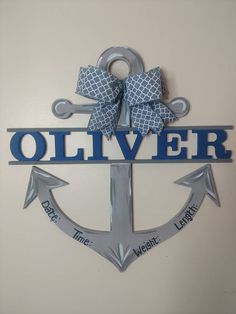 a metal anchor with a bow on it and the word'olliver '