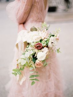 a woman in a pink dress holding a bouquet