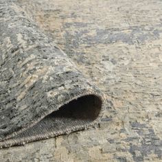 an area rug that has been rolled up on the ground with a hole in it