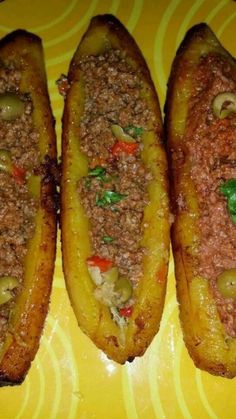 three stuffed potatoes sitting on top of a yellow and yellow plate with meat toppings