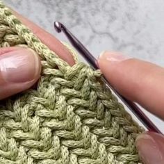 someone is knitting something with their fingers