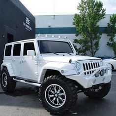 a white jeep parked in front of a building