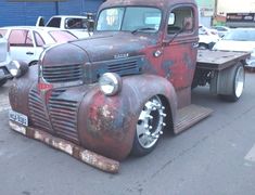 an old truck is parked in a parking lot