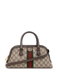 The Gucci Ophidia GG Supreme tote bag is crafted from canvas and features the iconic GG Supreme jacquard pattern, leather top handles, a detachable and adjustable leather shoulder strap, and a zip top fastening. It also features the iconic double G logo plaque and Web stripes. The interior is lined with microfiber and features a slip pocket. The bag is finished with metal feet and gold-tone metal hardware. It is a small tote bag, made in Italy.