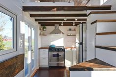 a tiny kitchen with an oven, stove and stairs leading up to the upper floor