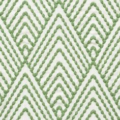 a green and white pattern with wavy lines on the fabric, as well as dots