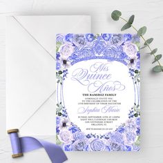 an elegant purple and blue wedding suite with flowers on the front is displayed next to a sprig of greenery