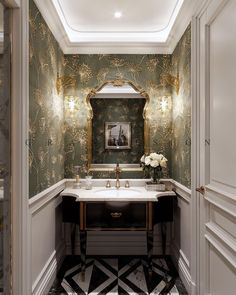 a bathroom with green and gold wallpaper, marble flooring and an ornate sink