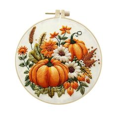 an embroidered hoop with flowers and pumpkins on it