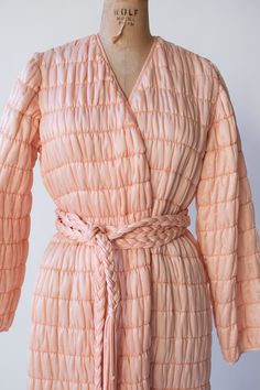 "1980s quilted peach robe by Mary Mcfadden. Wraps to fit with interior waist ties and an extra long braided belt. Hip pockets. Nylon, polyester and silk blend. - Size Small / Medium -  Labeled medium  Shoulder: 14.5\"  Bust: 40\"  Hips: 46\"  Length: 56\"  Sleeve Length: 22\"  Condition: Excellent!" Quilted Satin Robe, Mary Mcfadden, Quilted Robe, Velvet Corset, Print Chiffon Dress, Moschino Cheap And Chic, Gauze Dress, Braided Belt, Womens Robes