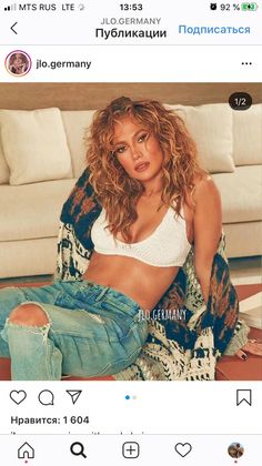 a woman sitting on top of a couch next to a white couch and wearing ripped jeans