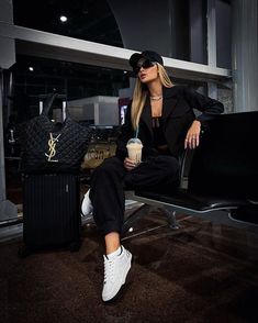 a woman sitting on top of a chair next to a black bag