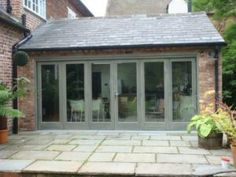 an open patio with sliding glass doors and potted plants