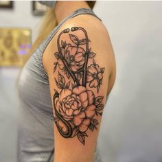 a woman's shoulder with roses and scissors on her arm, done in black ink