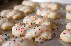 white frosted cookies with sprinkles on a baking sheet, ready to be eaten