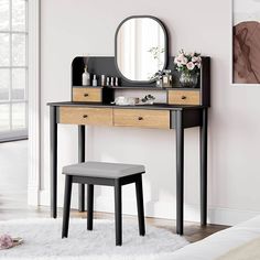 a dressing table with a mirror and stool in front of a pink wall, next to a white rug