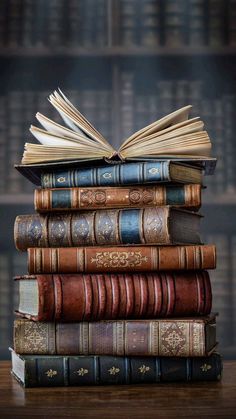 a stack of books sitting on top of a wooden table