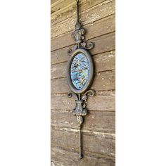 an ornate metal clock mounted to the side of a wooden building with blue and white designs on it