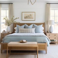 a bed with blue sheets and pillows in a bedroom