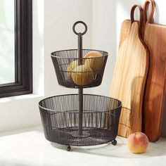 two metal baskets with apples in them sitting on a counter