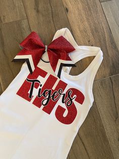 With cheer tryouts right around the corner, or Friday Spirit Day, this tank with matching bow combo is perfect for game day. Tank and bow only. Tank is a white or black Bella and canvas Razorback tank top. TO PURCHASE : Leave message in comments high school initials and mascot name along with school colors. Please specify size (youth or ladies) and color of tank top. Team discount for orders of 10 or more. Just message me so I can make a separate listing personally for you. Cheerleading Practice Wear, Cheer Camp Shirts, Cheer Team Shirts, Dance Team Uniforms, Cheer Practice Wear, Dance Team Shirts, Cheer Coach Shirts, Cheer Tops, Team Shirt Designs