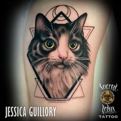 a black and white cat with yellow eyes in a triangle tattoo on the thigh or leg