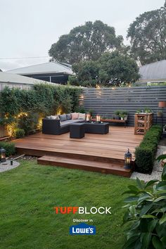 beautiful ground level deck in small yard with lights, candles, lush green grass and an edging garden with trimmed bushes Deck Platform Ground Level, Backyard Deck Landscaping, Raised Deck Ideas, Ground Level Deck Ideas, Ground Level Patio, Low Profile Deck, Deck Extension, Mixing Concrete