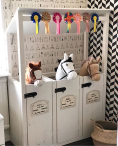 two stuffed animals are sitting on top of the toy storage cabinets in this playroom