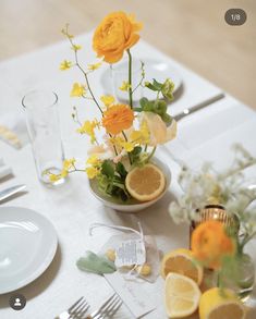 the table is set with flowers and lemons