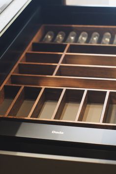 an open drawer with many compartments in it