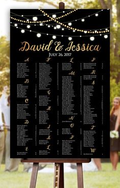 a black and gold wedding seating chart with string lights