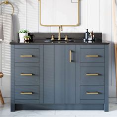 a bathroom vanity with two sinks and gold handles