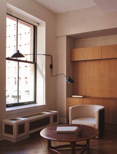 a living room with a couch, chair and table next to a window in the corner